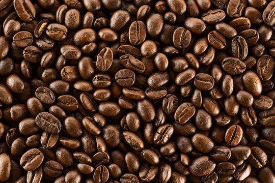 Brown roasted coffee beans, seed on dark background. Aroma, black caffeine drink. Closeup isolated energy mocha, cappuccino ingredient.