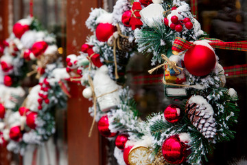 Christmas wreath on a door with red decoration, balls and snow