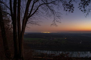 View of bavarian landscape with lights from a refinery in the background. Refinery lights shining bright after sunset. Rural scene with refinery