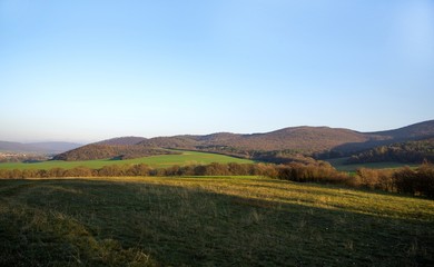 Obraz premium Green field and sky. Mountain at the back