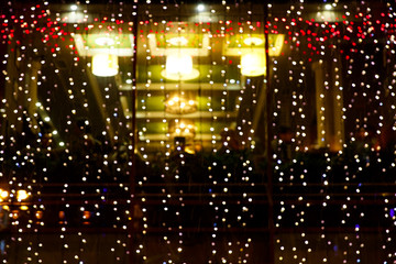 Fototapeta na wymiar Christmas Bokeh background. Blurred photo of shop window or cafe window