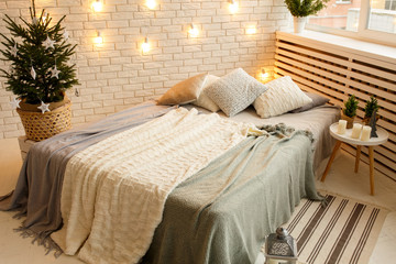 Winter Christmas decorations in scandinavian style. Pillows on the bed.