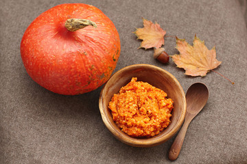 Autumn pumpkin soup, rustic overhead scene on a wood bowl