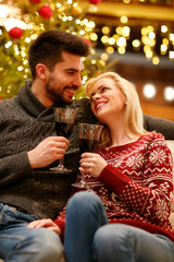 Christmas holiday - romantic couple toasting with red wine.