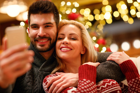 lovely couple taking selfie with smartphone on Christmas .