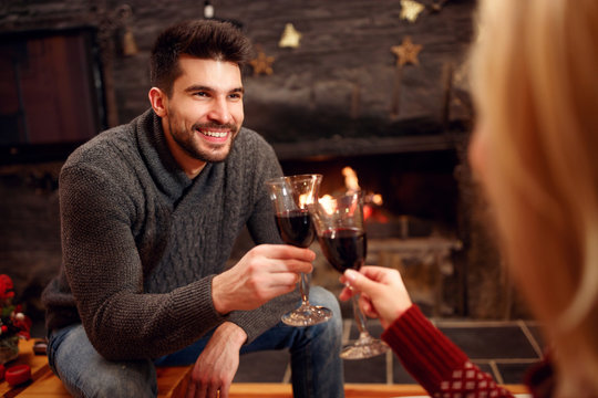 holidays, Christmas, season and people concept - couple toasting delicious red wine.