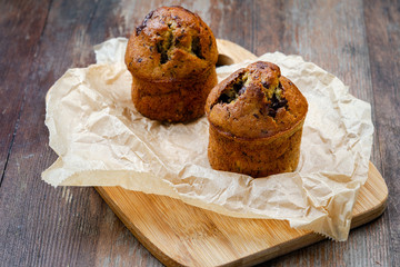 Chocolate banana muffins on wooden background