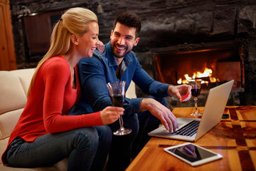 Smiling couple shopping online with laptop and credit card buying online with ecommerce