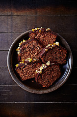 Chocolate cake with nuts and orange peel for Christmas. Flat lay. Wooden background