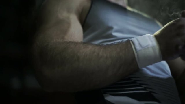 Muscular man near heavy barbells