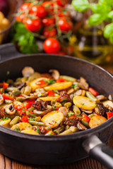 Fried pan vegetables, with mushrooms and dried tomatoes. Seasoned with a mix of herbs.