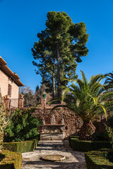 Fountain with sculptures in little opened patio in Alhambra Garden