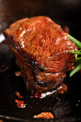 Juicy beef steak and herbs spices on cast iron skillet pan