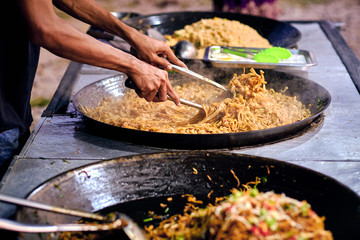 Fried noodles in a wok. Asian, Indian and Chinese street food. Food court on local market of Langkawi island, Malaysia..Traditional asian street food.