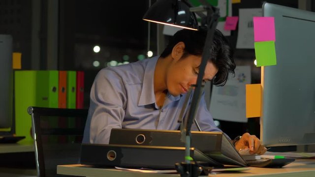 Businessman hard working with desktop computer to late night at office. Business people work overtime. Concept of salary man, fatigue and tired.