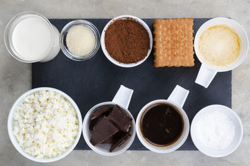 Ingredients for cheesecake on a black background