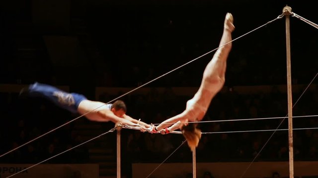 Acrobats perform exercises on the bar in the circus arena