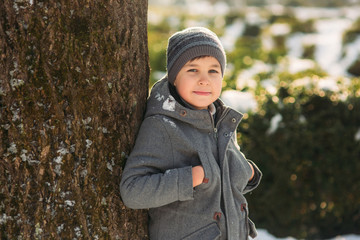 In perfect winter weather the boy poses to the photographer