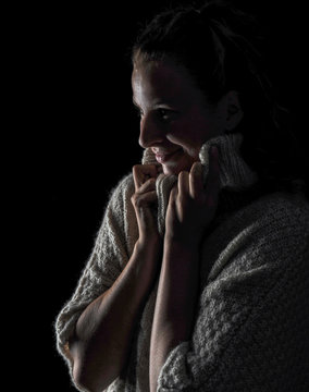 blonde frau stehend in dicken pullover schal lachend eingemummelt winter