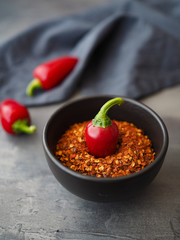 Chilli peppers in black bowl on dark table. Close up.