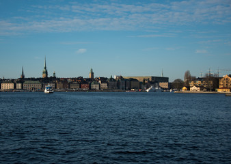 Fototapeta na wymiar Water view over Stockholm an winter day, snowy, sun and clear sky over boats and landmark