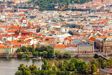 Prague, Bohemia, Czech Republic. Scenic view of bridges on the Vltava river and of the historical center of Prague : buildings and landmarks of old town with red rooftops and houses.