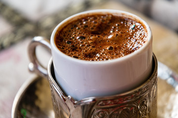 Close-up shot of a cup of turkish coffee with silver cup holder