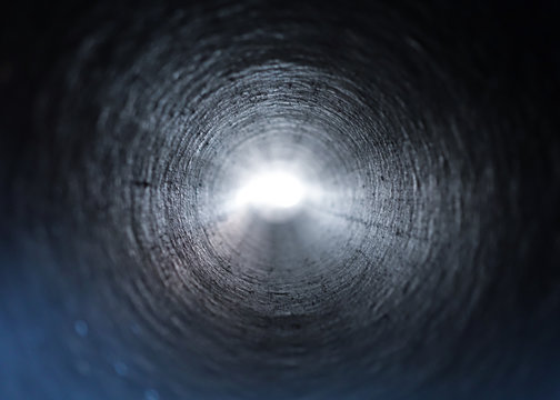 Inside view of a round plastic pipe. Tunnel to the light from the dark