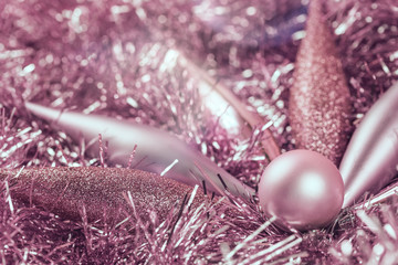 Pastel pink Christmas decorations on tinsel monochrome with copy space