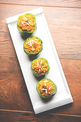 Stuffed capsicum or bharwa shimla mirchi is a popular Indian main course recipe. Served in a plate over moody background. Selective focus