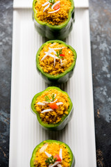 Stuffed capsicum or bharwa shimla mirchi is a popular Indian main course recipe. Served in a plate over moody background. Selective focus