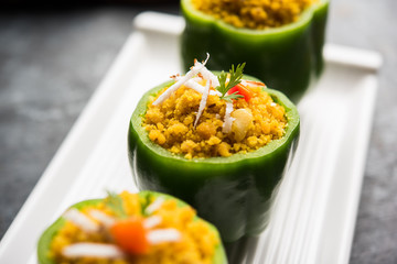 Stuffed capsicum or bharwa shimla mirchi is a popular Indian main course recipe. Served in a plate over moody background. Selective focus
