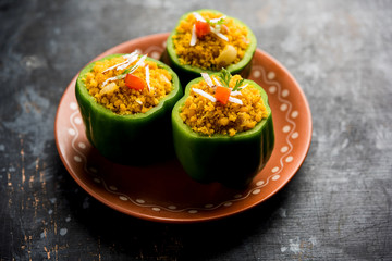 Stuffed capsicum or bharwa shimla mirchi is a popular Indian main course recipe. Served in a plate over moody background. Selective focus