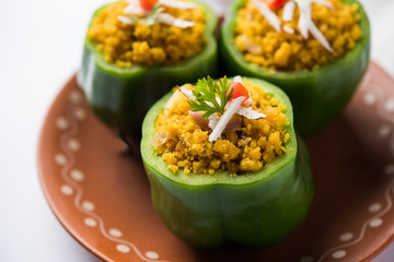 Stuffed capsicum or bharwa shimla mirchi is a popular Indian main course recipe. Served in a plate over moody background. Selective focus