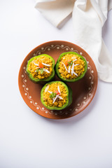 Stuffed capsicum or bharwa shimla mirchi is a popular Indian main course recipe. Served in a plate over moody background. Selective focus