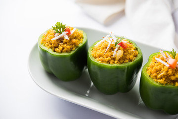 Stuffed capsicum or bharwa shimla mirchi is a popular Indian main course recipe. Served in a plate over moody background. Selective focus