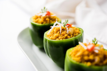 Stuffed capsicum or bharwa shimla mirchi is a popular Indian main course recipe. Served in a plate over moody background. Selective focus