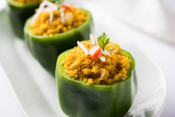 Stuffed capsicum or bharwa shimla mirchi is a popular Indian main course recipe. Served in a plate over moody background. Selective focus