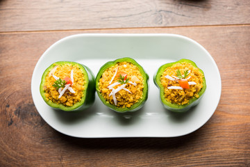 Stuffed capsicum or bharwa shimla mirchi is a popular Indian main course recipe. Served in a plate over moody background. Selective focus