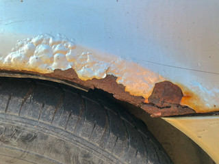 Close up of rust over a wheel on a silver car