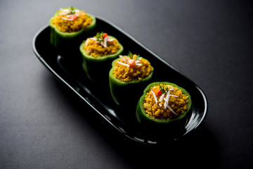 Stuffed capsicum or bharwa shimla mirchi is a popular Indian main course recipe. Served in a plate over moody background. Selective focus
