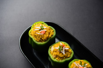 Stuffed capsicum or bharwa shimla mirchi is a popular Indian main course recipe. Served in a plate over moody background. Selective focus