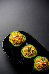 Stuffed capsicum or bharwa shimla mirchi is a popular Indian main course recipe. Served in a plate over moody background. Selective focus