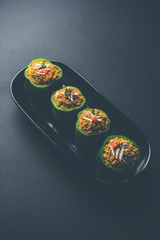 Stuffed capsicum or bharwa shimla mirchi is a popular Indian main course recipe. Served in a plate over moody background. Selective focus