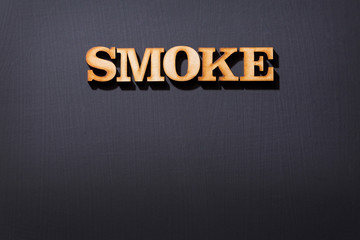 The word smoke in wooden letters - Black background