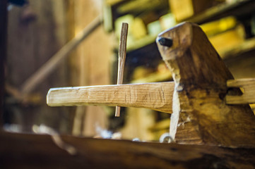 Carpenters wooden block with dowel in wooden arm pointing left, with blurred background