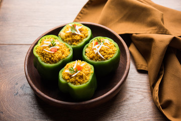 Stuffed capsicum or bharwa shimla mirchi is a popular Indian main course recipe. Served in a plate over moody background. Selective focus