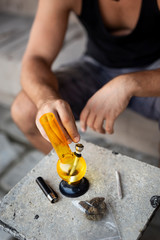 Man filling up the bong with cannabis