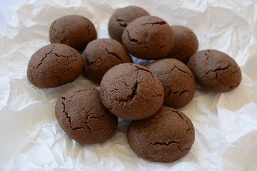 Closeup homemade crisp, cracked cocoa cookies with liquid chocolate with blurred background