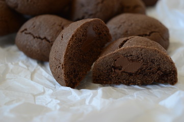Closeup homemade crisp, cracked cocoa cookies with liquid chocolate with blurred background